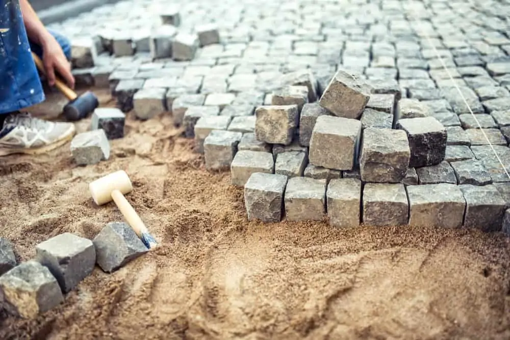 man laying stone bricks