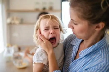 Mother holding a screaming toddler