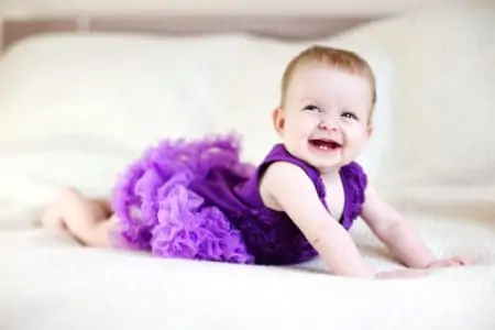 Beautiful baby girl smiling in her purple tutu
