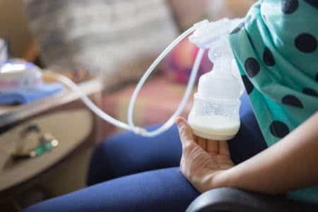 Mother pumping milk with an automatic breast pump
