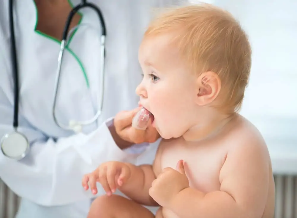A doctor checks baby's teeth