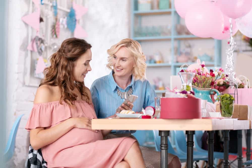 A pregnant woman talking to her friend at a baby shower
