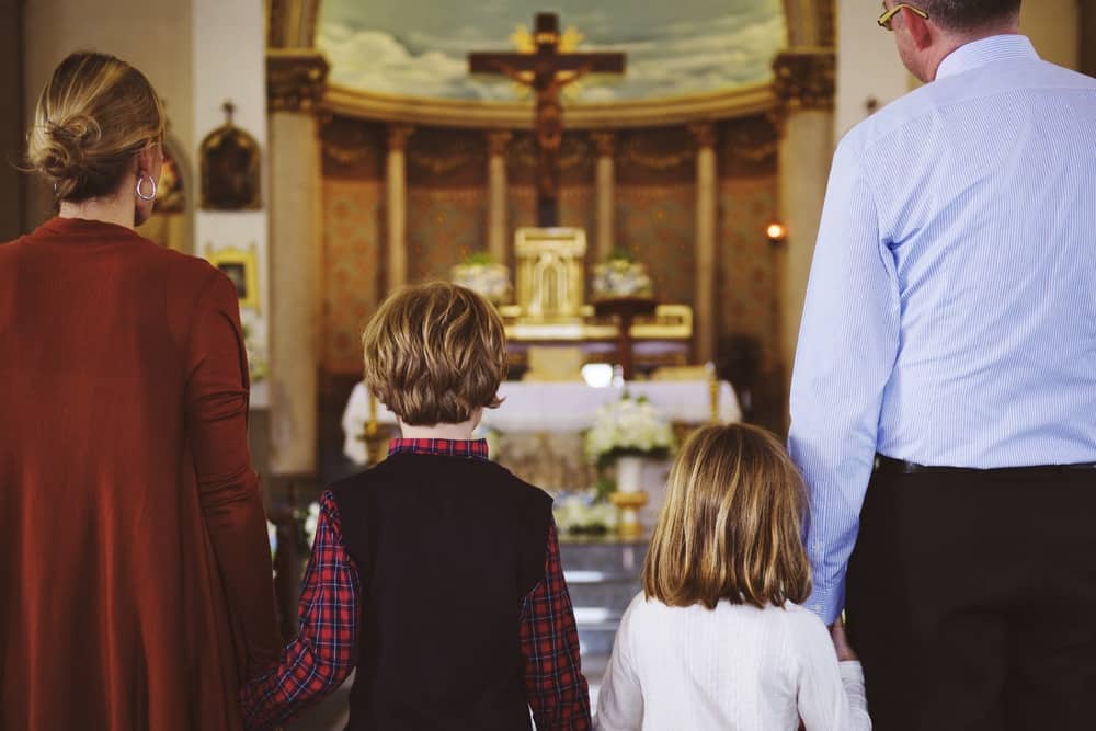 Kids and their parents praying in church