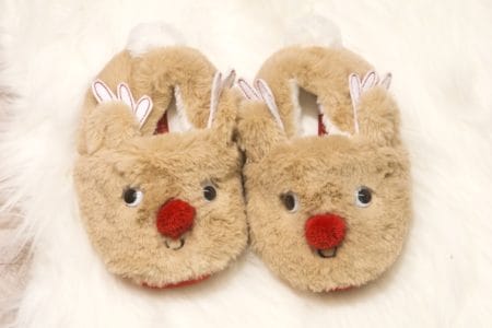 Cute kids slippers on a white fluffy carpet