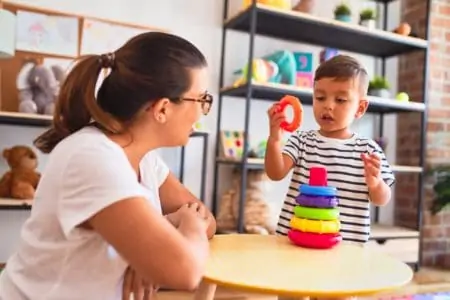 A woman using toys to help toddler talk
