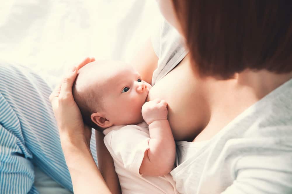 A mother breastfeeding her newborn baby at home