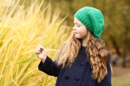 Cute Irish girl in a green hat having fun in the park