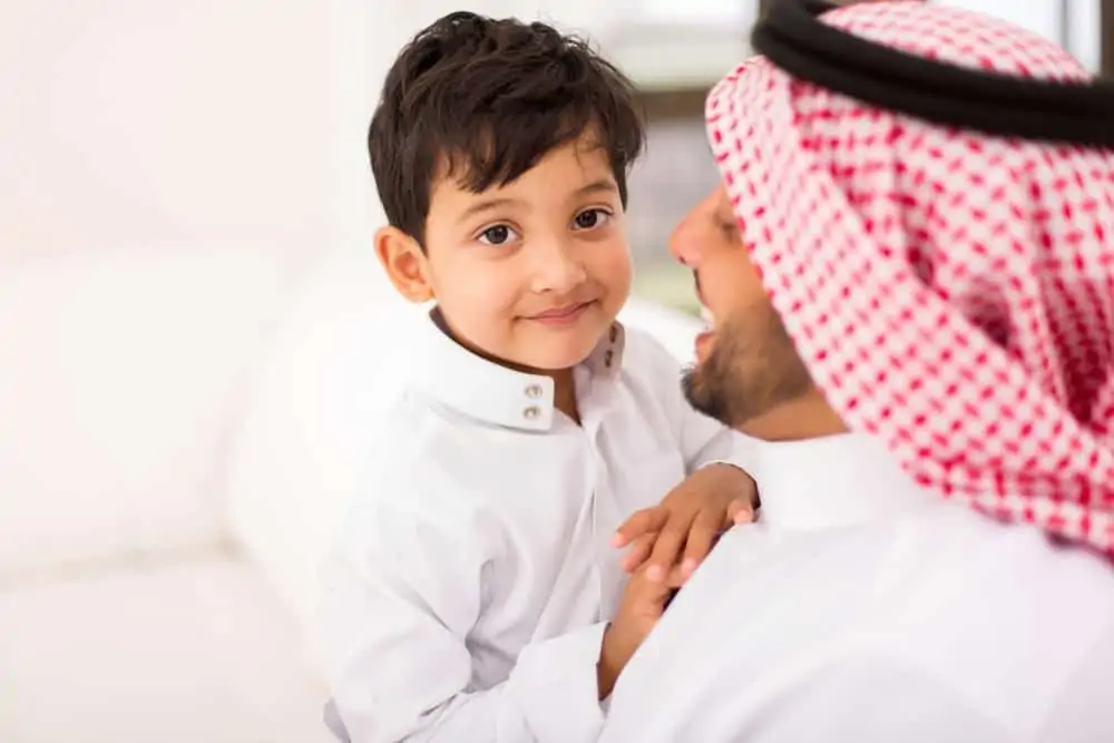 Happy Arabic boy with his father at home.