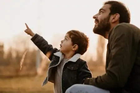 Turkish boy looking at the sky with his father in the park.