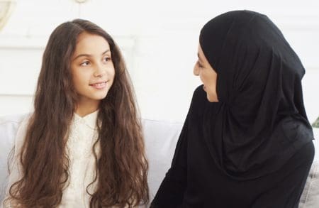 Arabic girl talking to her mother at home