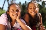 Two smiling Brazilian girls are playing in the park