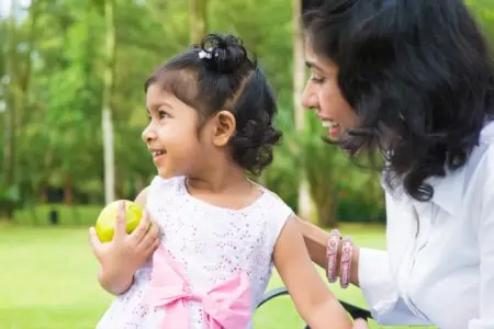 Little Indian girl playing with her mother in the park