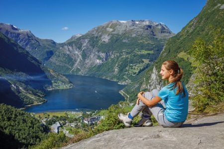 Cute Norwegian girl looking at Geirangerfjord