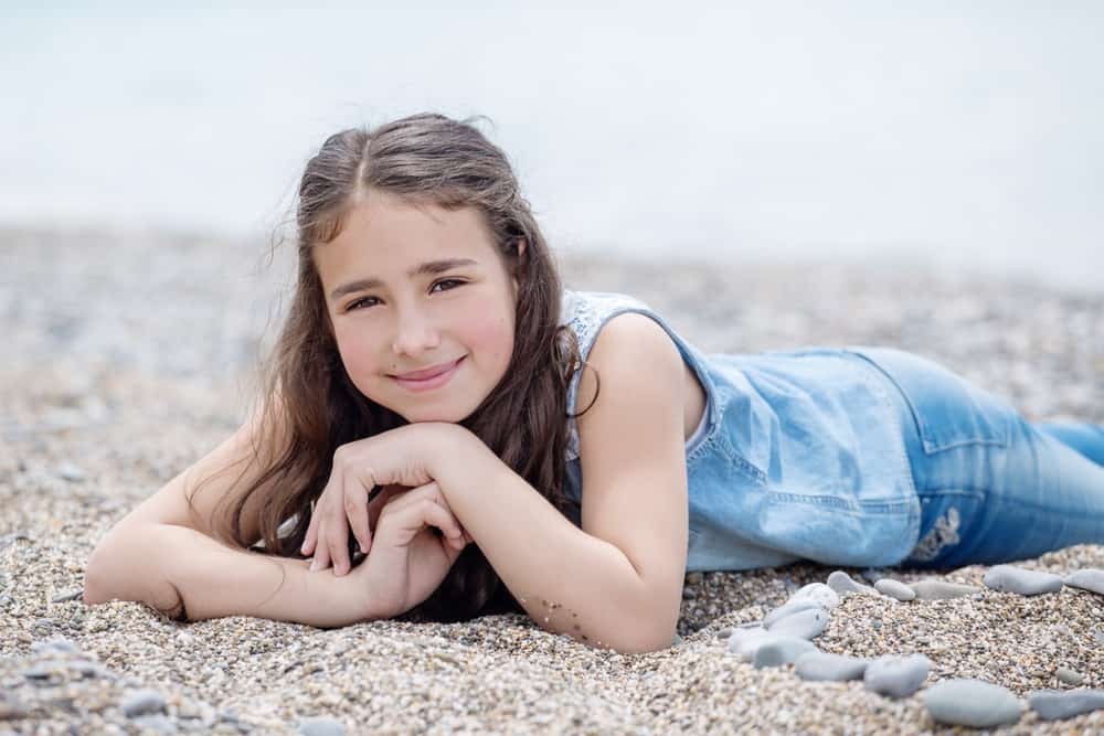Happy Welsh girl lying on the beach