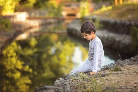 Little boy sitting near the river