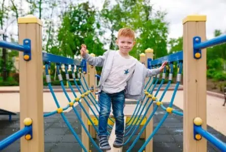 Cute cheerful boy playing on the playground