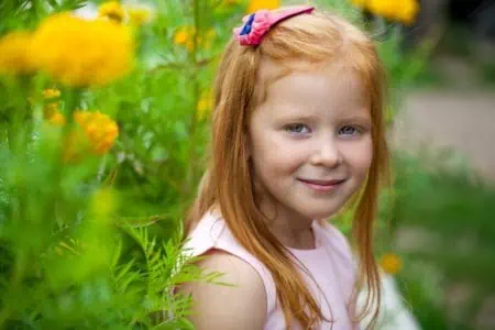 Happy red-haired girl playing in the park
