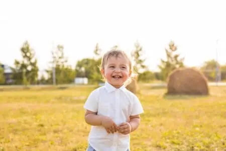 Cute little boy smiling broadly on sunny day at the park