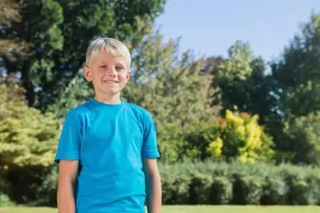 Smiling blonde young boy in the park