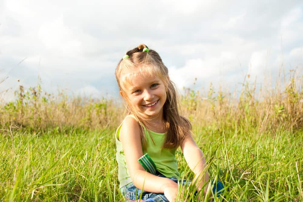Smiling beautiful little girl in meadow