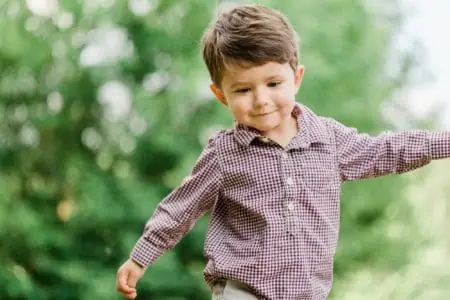 Adorable cheerful cute little boy having fun in park
