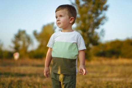 Cute little boy standing in the field