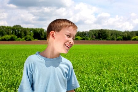 Young boy smiling in the park on sunny day