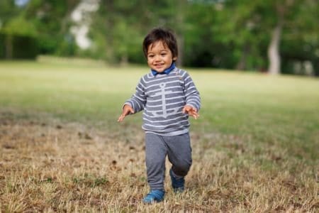 Cheerful little baby boy playing outdoor in the park