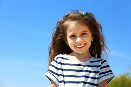 Smiling beautiful girl on sky background