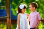 Cute girl and boy playing together outdoors on a summer day