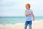 Happy Australian boy playing on the beach