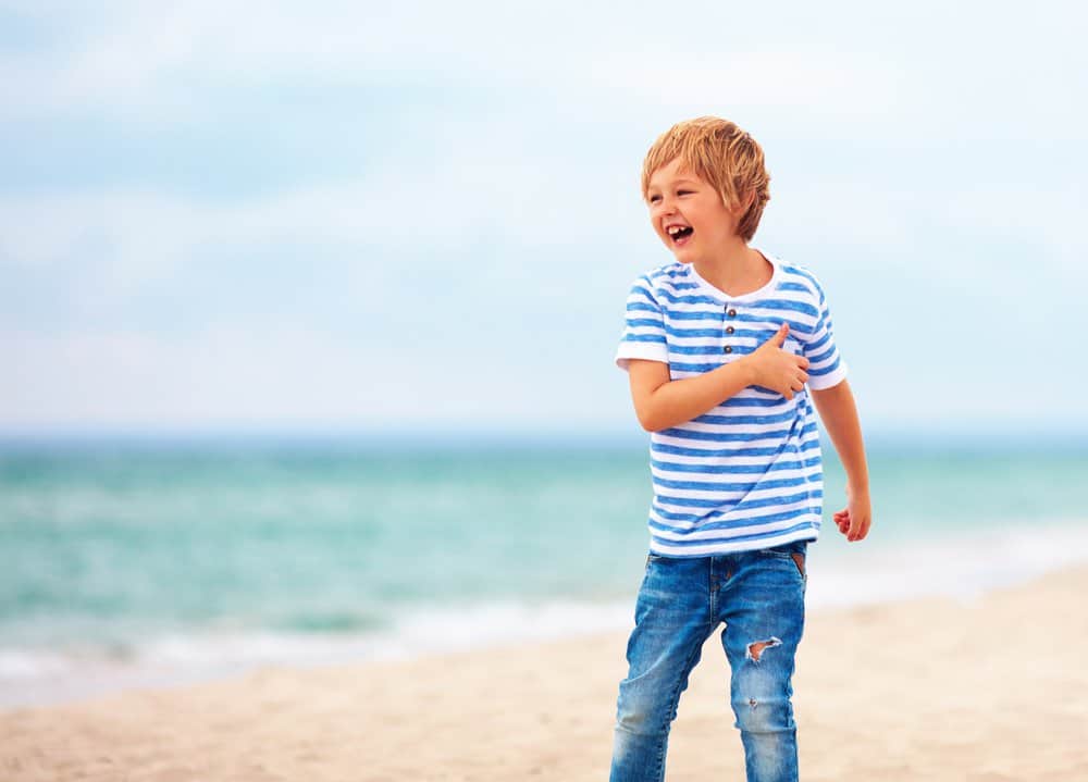 Happy Australian boy playing on the beach