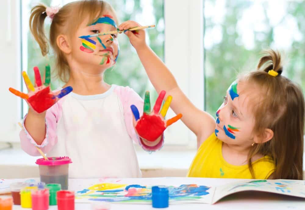 Two little kids painting each other's faces