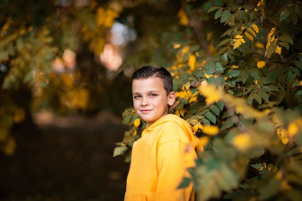 Cute little boy in yellow hoodie spending time in the park