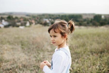 Adorable little girl in the meadow in the mountains.