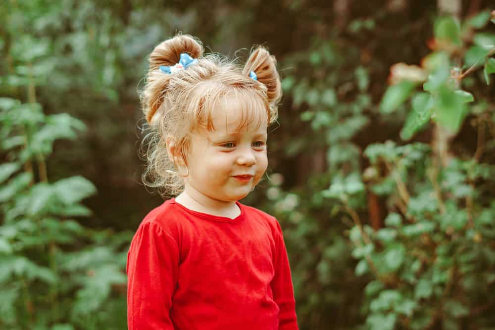 Adorable little young girl in red long sleeves in the park