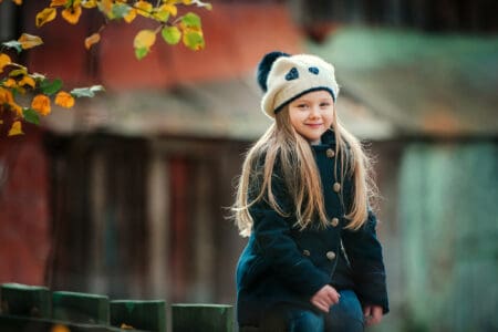 Adorable young girl wearing beanie in autumn park