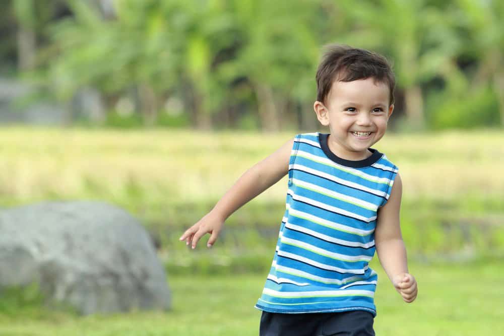 Cheerful little boy running in the park