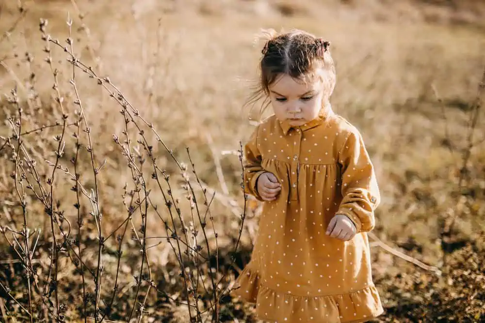 Adorable girl wearing mustard dress outdoors
