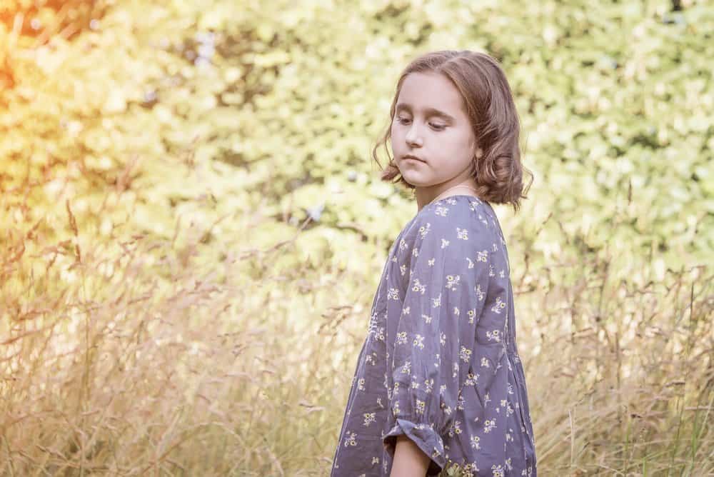 Little girl wearing floral dress in the meadow