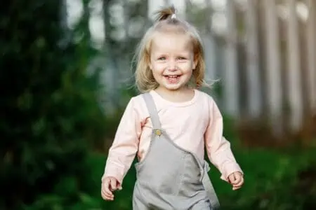 Cheerful little girl wearing jumper outdoors