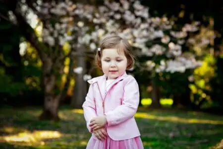 Cute little girl wearing pink clothes in the park
