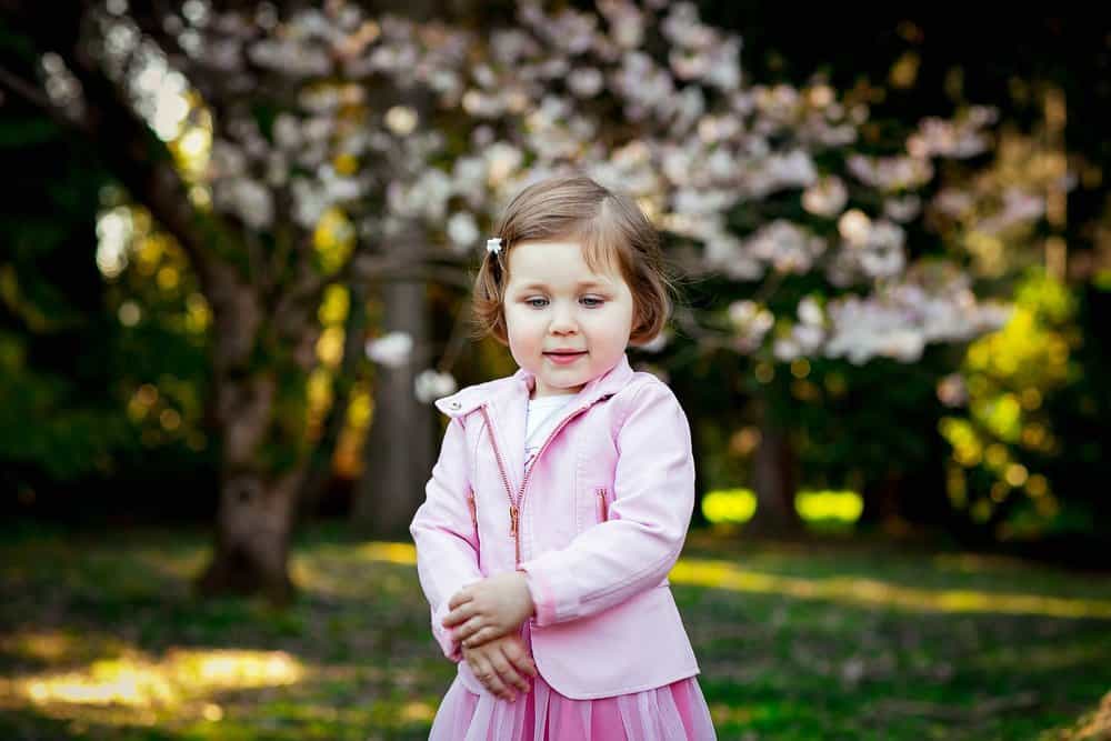 Cute little girl wearing pink clothes in the park