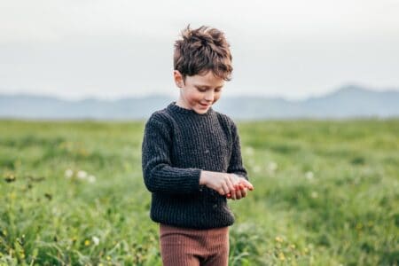 Happy boy picking flowers in the field