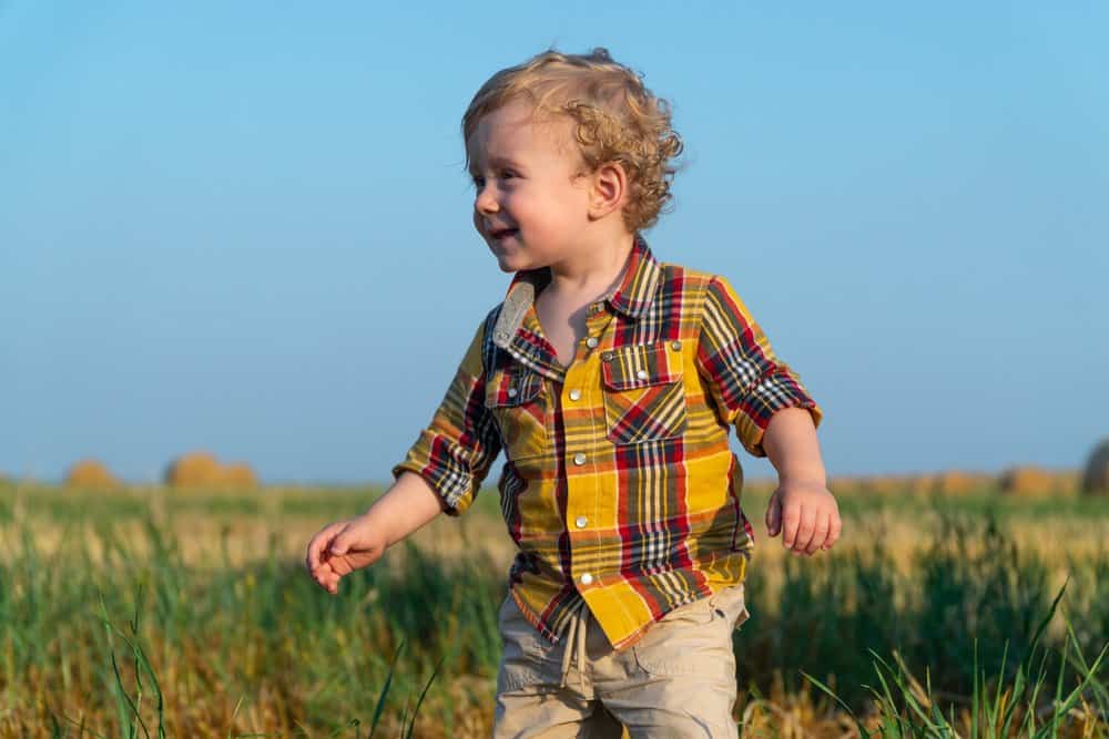 Happy little boy playing in the field