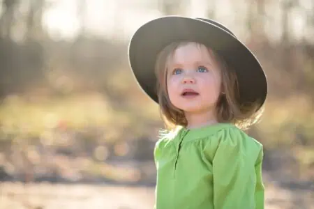 Cute little girl in a hat spending time outdoors