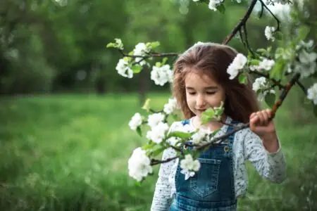 Happy little girl playing under a tree