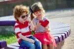 Little boy and girl holding a red heart
