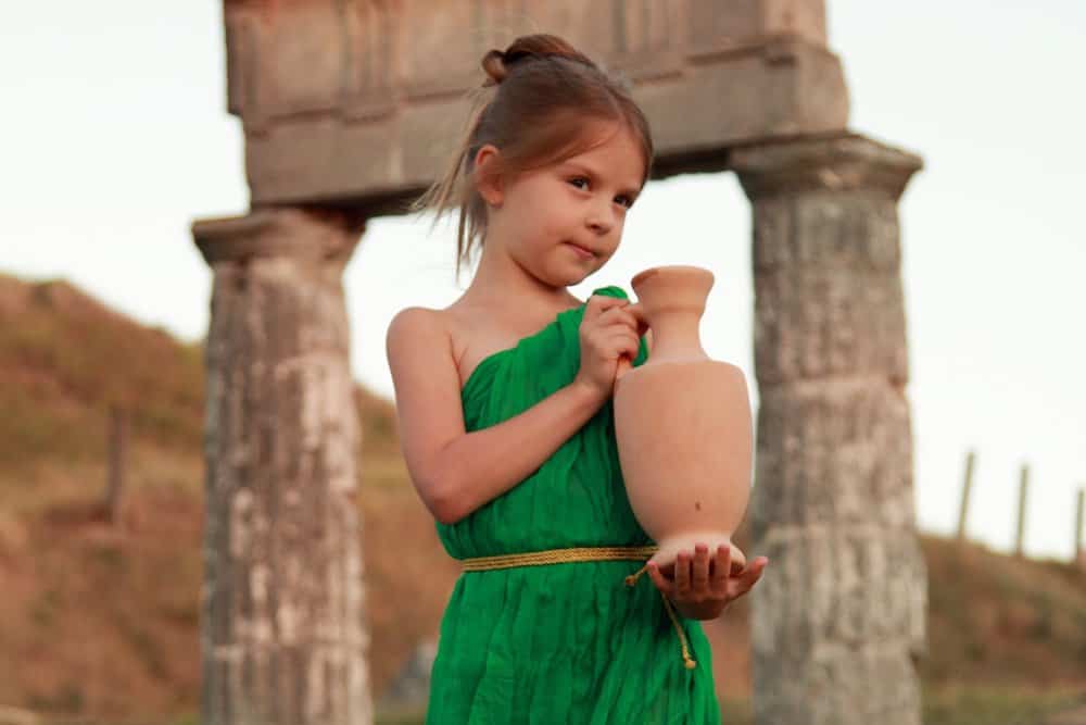 Little Roman girl in green dress holding an amphora