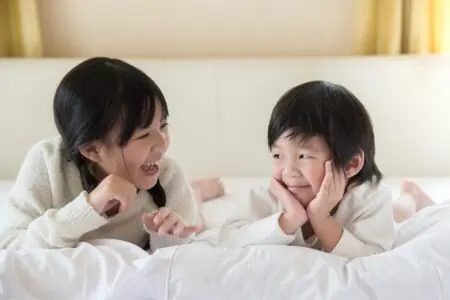 Cute Japanese siblings lying on the bed